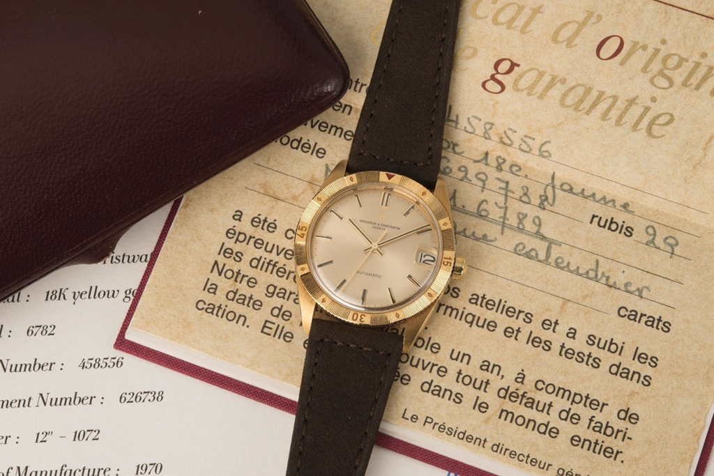 flatlay photo of a 1960s Vacheron Constantin Turnograph with papers and box