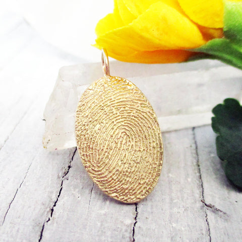 Flat gold oval fingerprint pendant from digital image