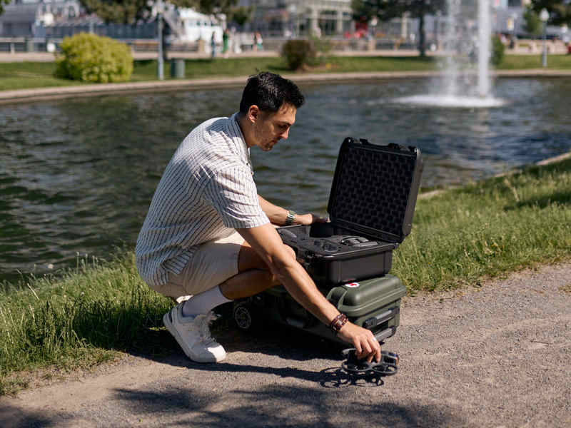 Un utilisateur de drone place le DJI Avata 2 à l'intérieur du Nanuk 925 valise dans un parc.