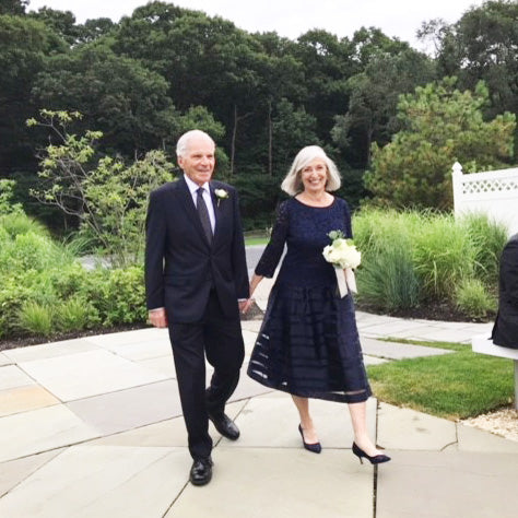 Grandmother of the Bride and Grandmother of the Groom holding hands walking at outdoor ceremony