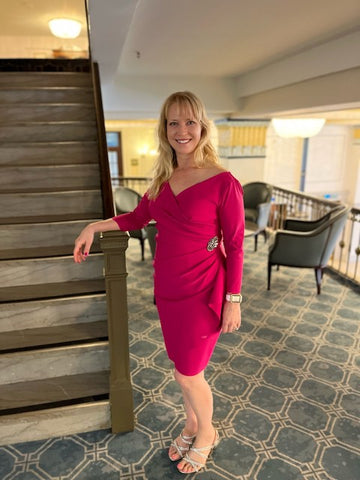 Woman in pink knee-length dress at formal event