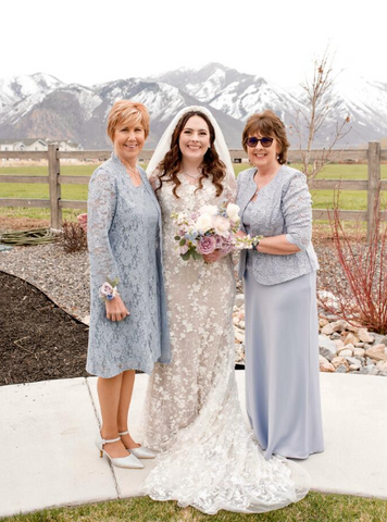 Bride smiling with relatives outside in front of mountains