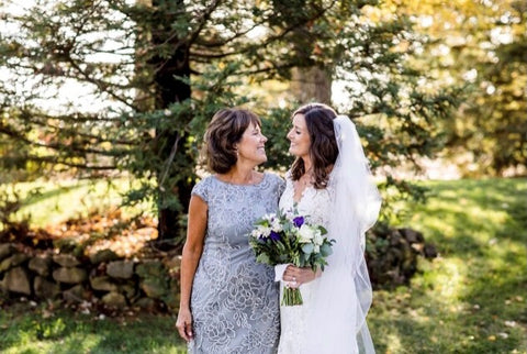 Image of the bride and the mother of the bride outdoors on wedding day