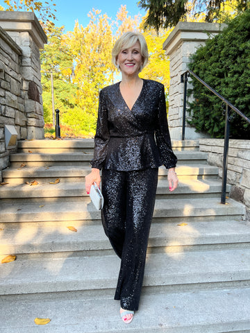 Image of a woman on outdoor steps in a stunning black sequin evening separates outfit