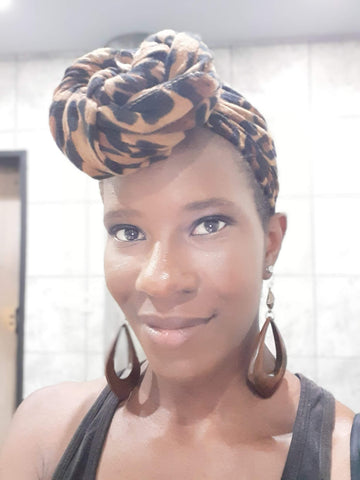 Smiling Black Woman with Cheetah Print Scarf wrapped on head. 
