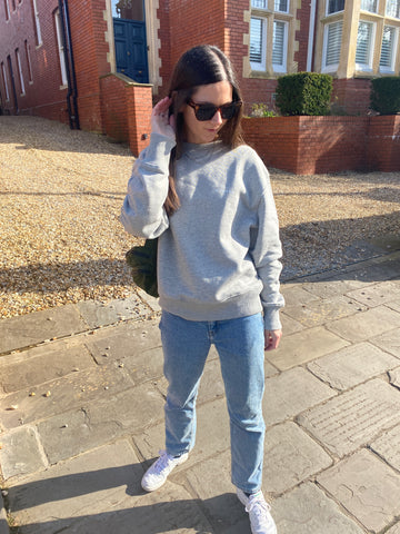woman in grey Bonne Aventure sweatshirt with jeans and trainers