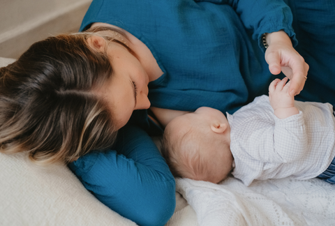 Mom breastfeeding her baby lying down