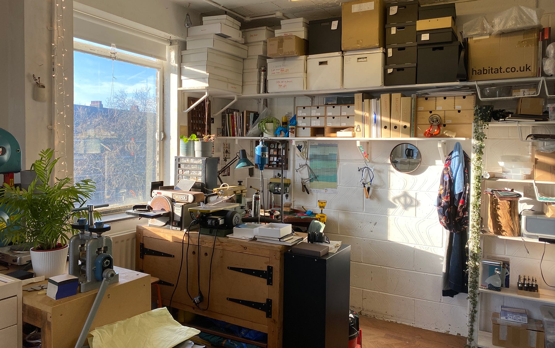 inside Emily's studio, showing benches and tools with sunlight streaming through the window