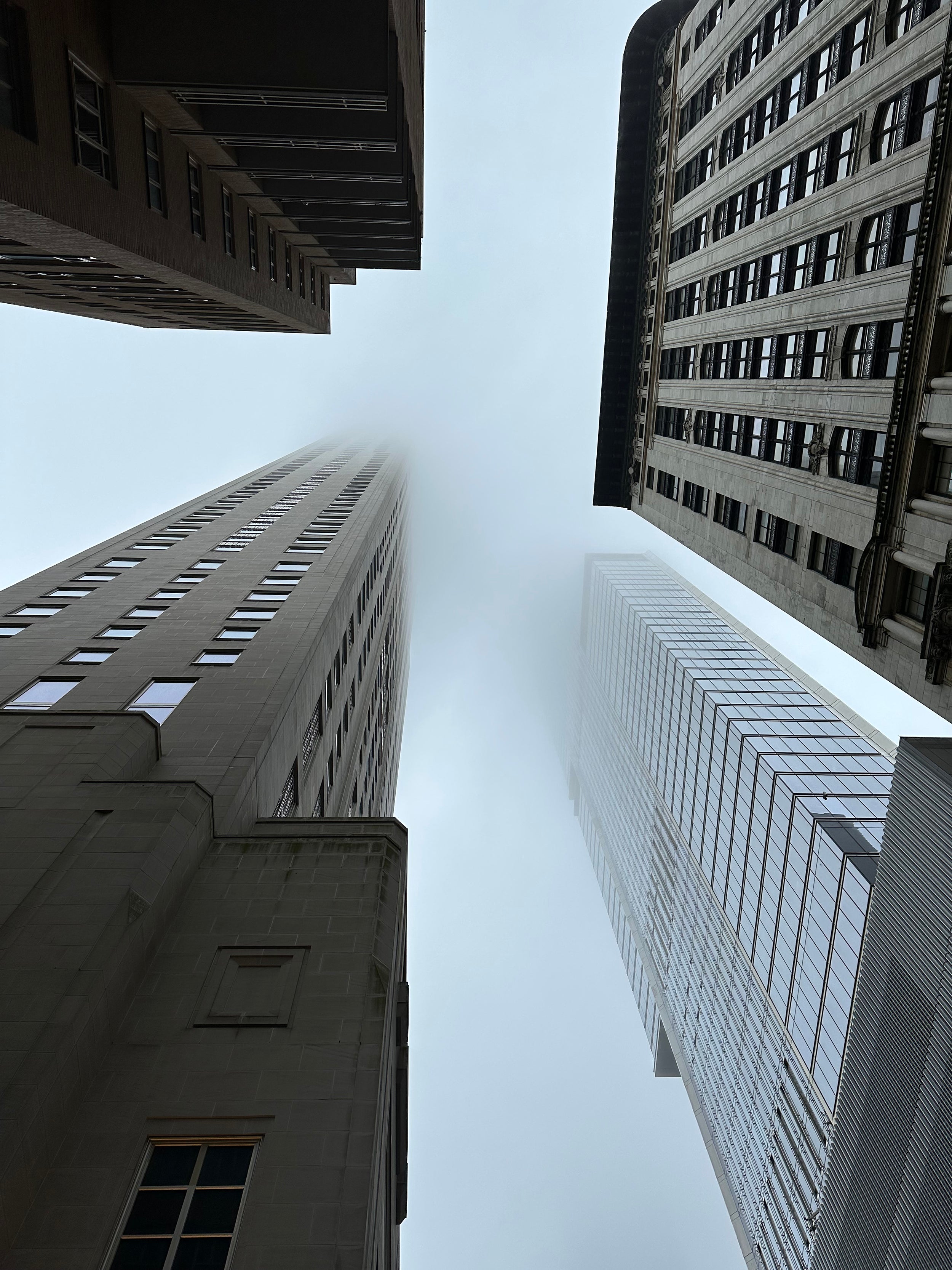 Looking up at buildings disappearing into clouds