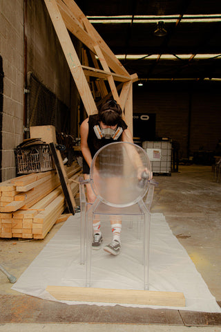 Claire from ACID FLWRS painting a Ghost chair in a warehouse