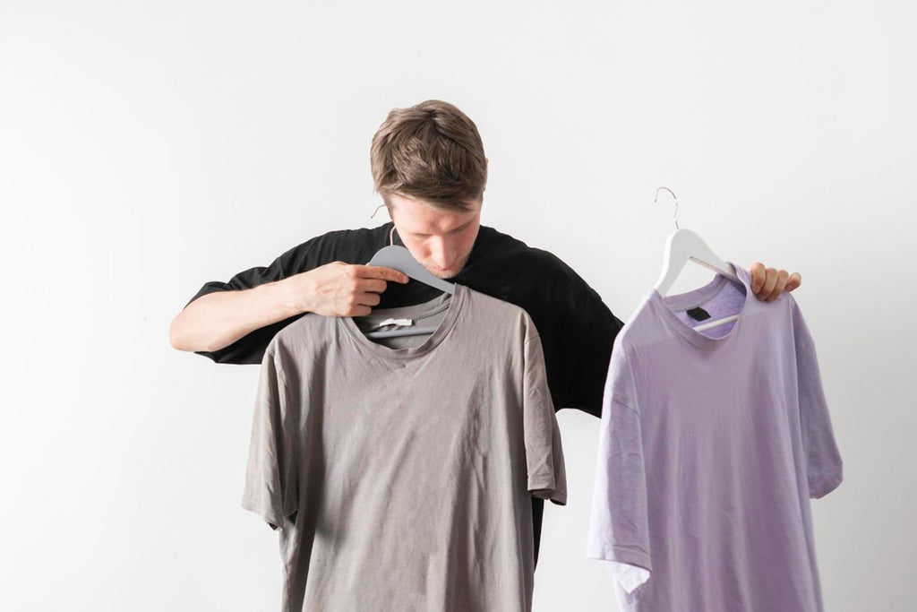 man weighing and choosing t-shirt