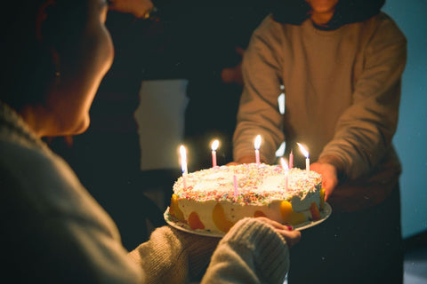 persone con torta di compleanno in mano