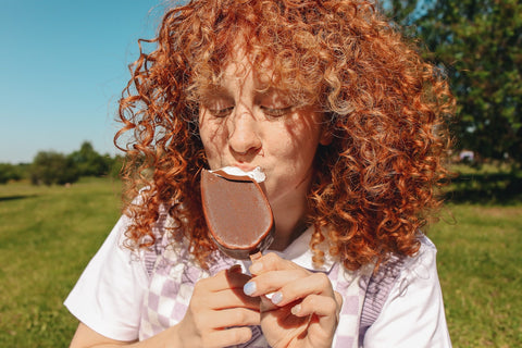 ragazza dai riccioli rossi che mangia il gelato