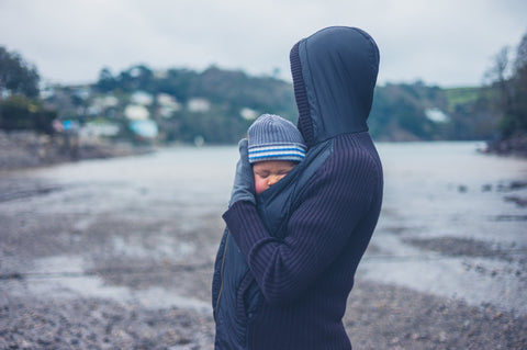 mom is carrying a baby in winter