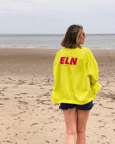 ALICE WEARING LIME TRACKER JACKET AT THE BEACH