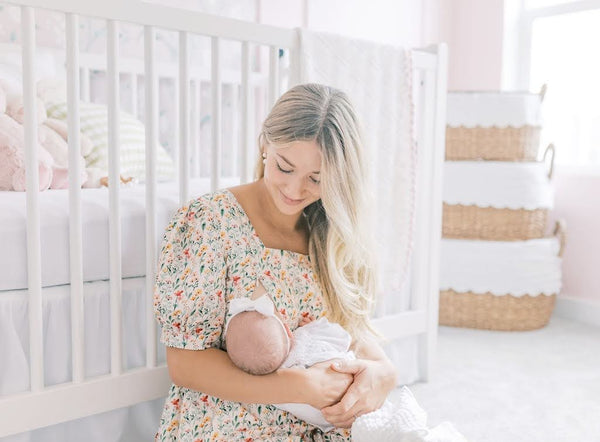 Woman breastfeeding her baby while wearing Versa Everywhere Dress with Nursing Zippers in Harvest Blooms (ready-to-ship)