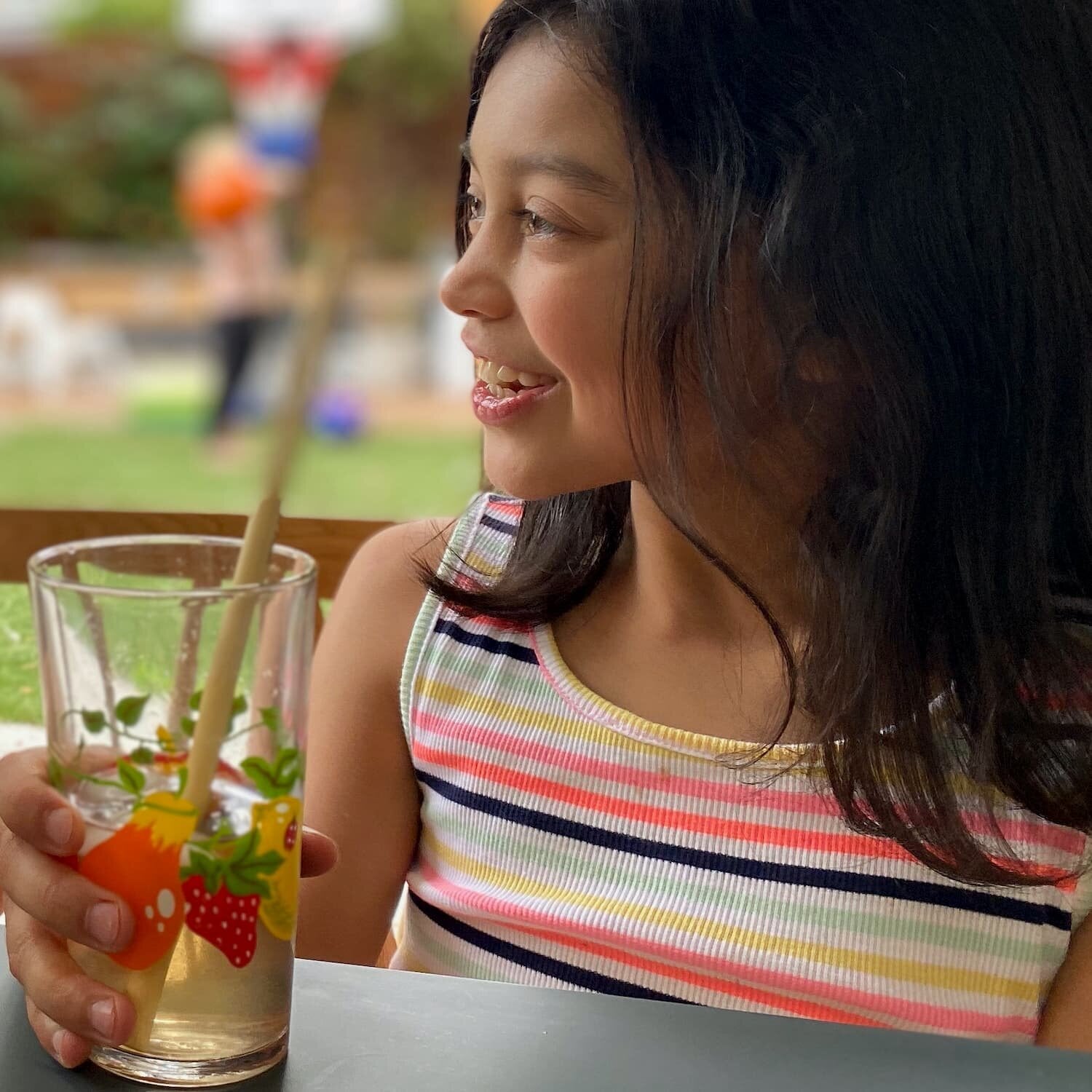 girl drinking iced tea from glass with straw