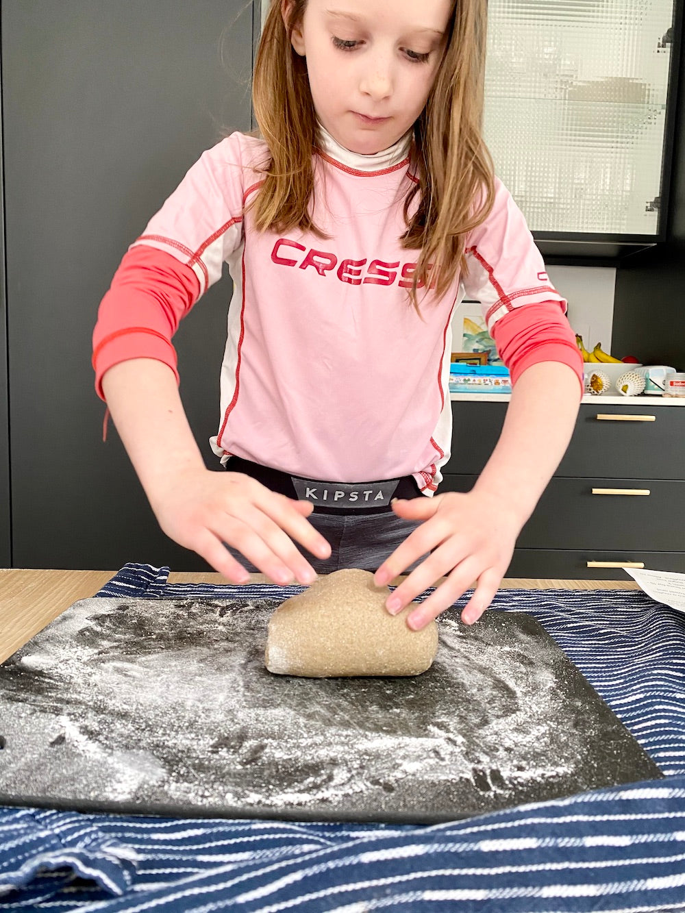 girl kneading dough for hot cross buns