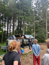 people in front of bioreactor in front of forest