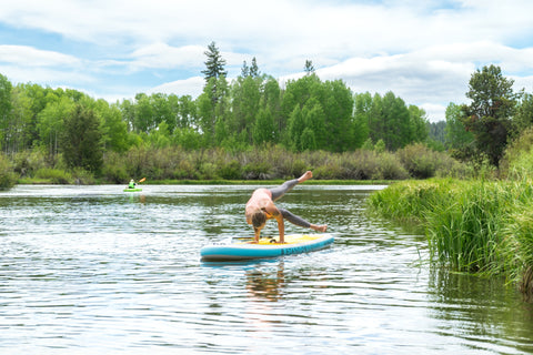 women doing yoga on stand on liquid namaste inflatable stand up paddleboard