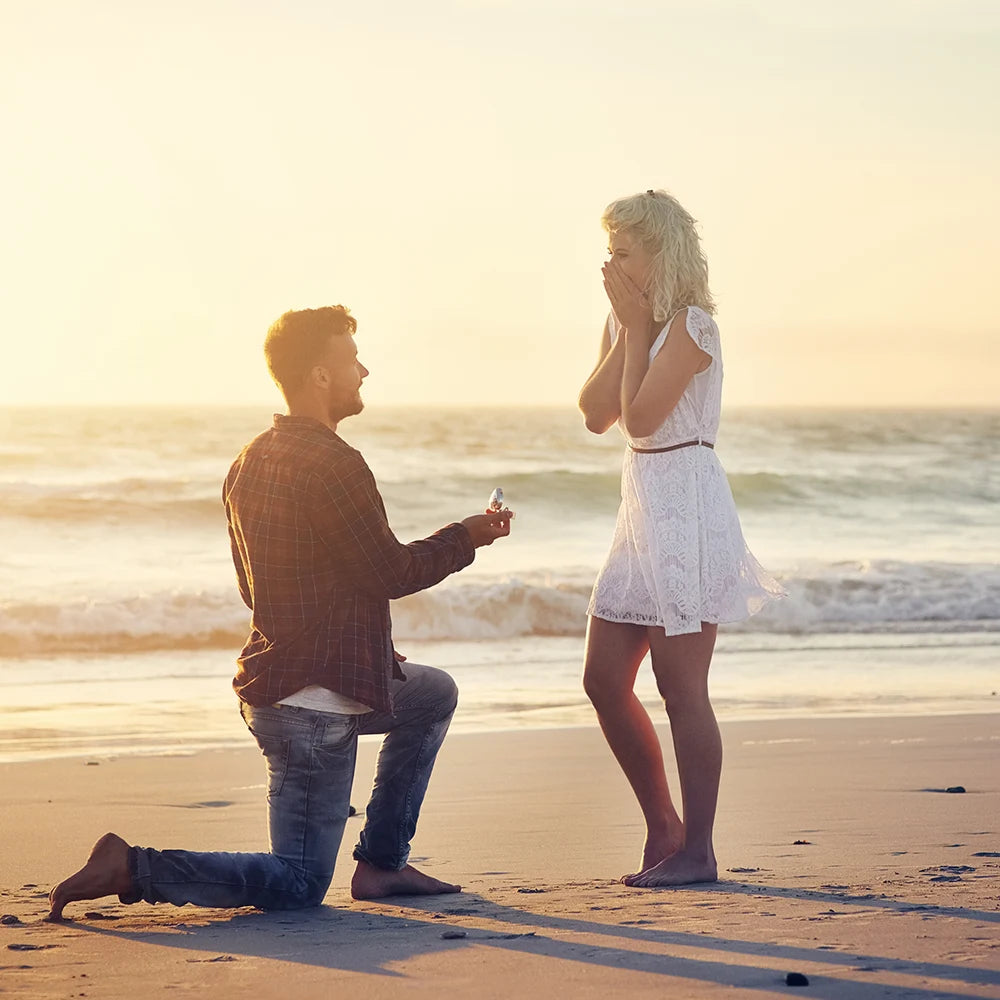 Man unboxing the ring on beach to propose his love partner for wedding at sunset time