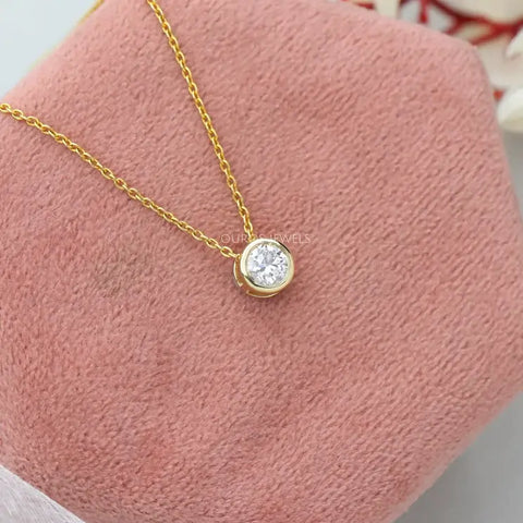 Finest round-cut diamond pendant in radiant yellow gold, expertly bezel-set for timeless sophistication—a captivating accessory for women.