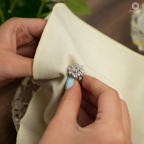 Close-up of hands delicately cleaning and maintaining prong settings in rings with a soft brush, emphasizing the importance of proper care for preserving the brilliance and longevity of precious gemstones.