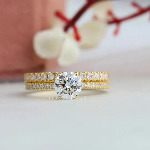 1.05 carat weights round cut diamond bridal set wedding ring with 0.85 carat round shaped accent stones in 18KT yellow gold.