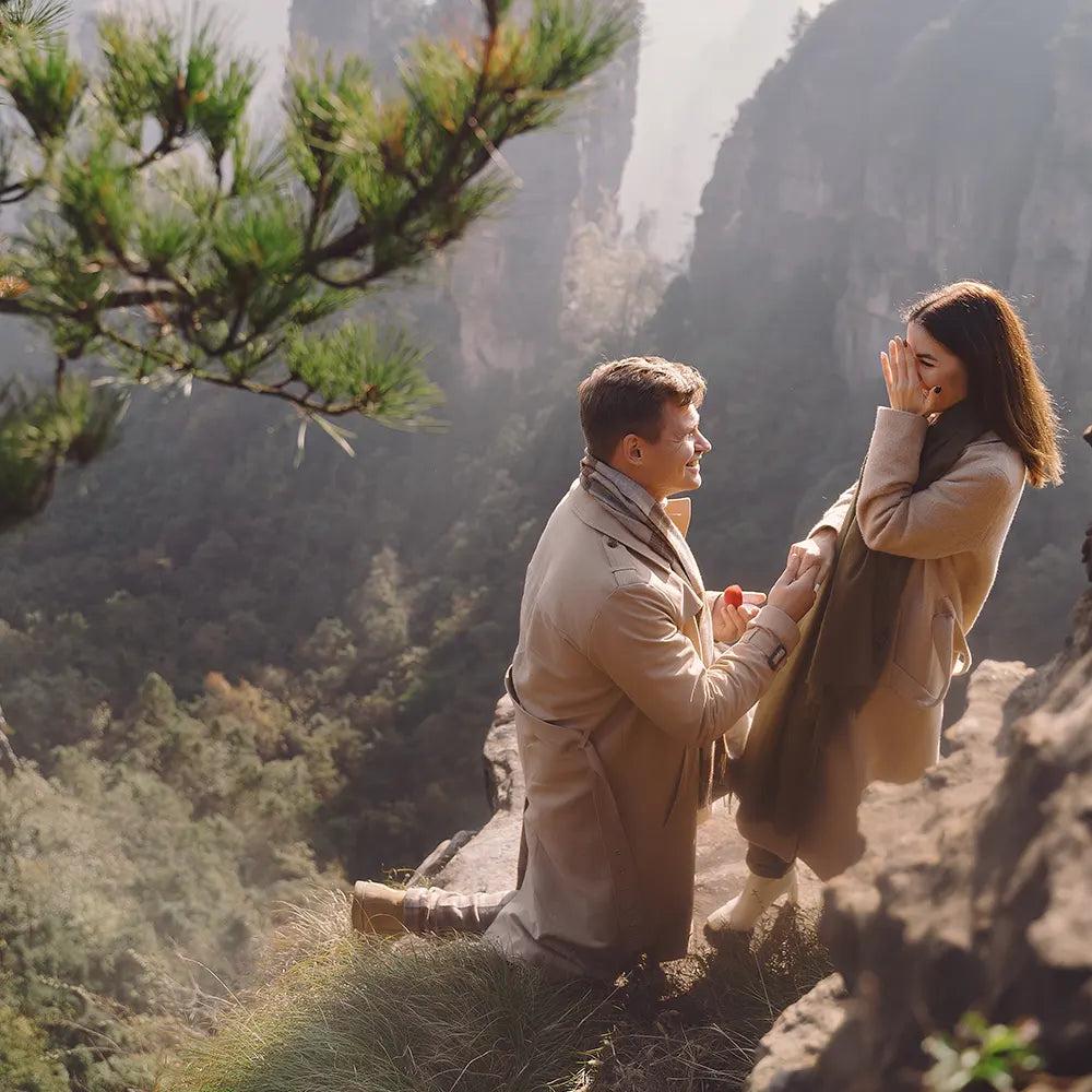 Boyfriend proposes to a girlfriend with a ring on the summit of the mountain as a fresh promise for a future