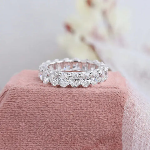 Oval cut lab diamond wedding eternity band made with round prong settings and white gold metal.