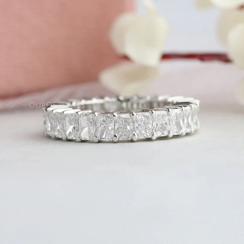 Radiant cut diamond wedding eternity band for women made with a claw prong and shared surface prong settings that looks more pretty on the hand of fiancée.
