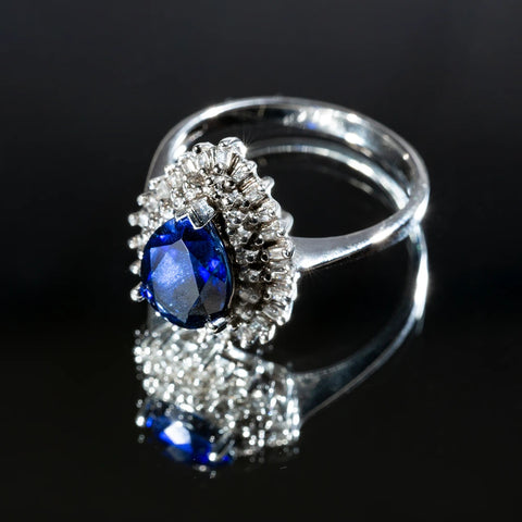 Blue pear shaped gemstone halo engagement ring made with Victorian-era patterns that looks beautiful and excellent on the finger.