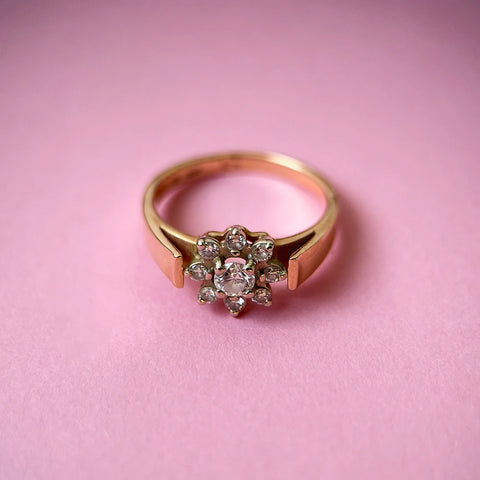 Round brilliant cut diamond flower style vintage rose gold engagement ring to be presented on a pre-wedding ceremony in front of family and friends.