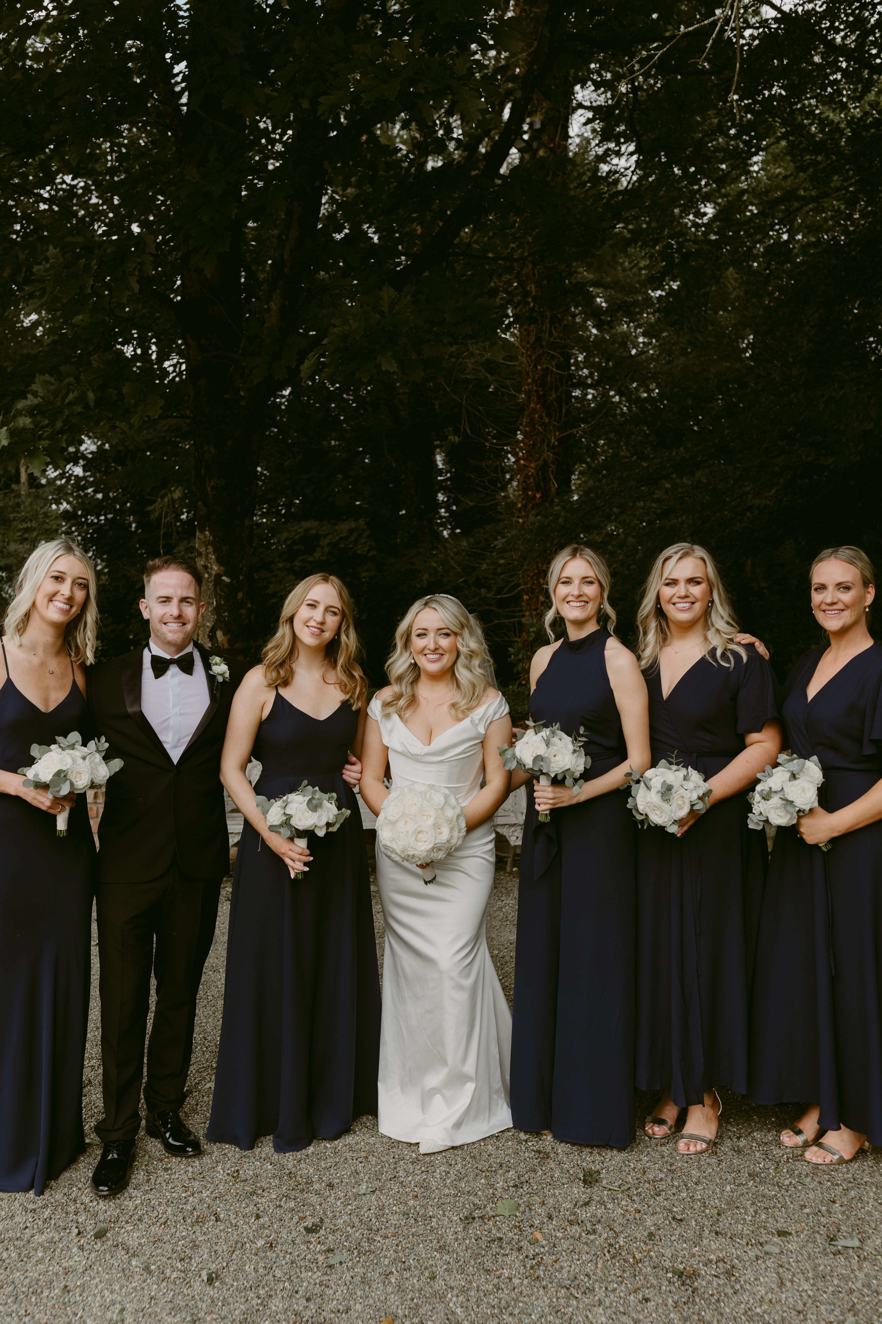 Bride and groom with bridesmaids in ink navy blue bridesmaids dresses mix & match