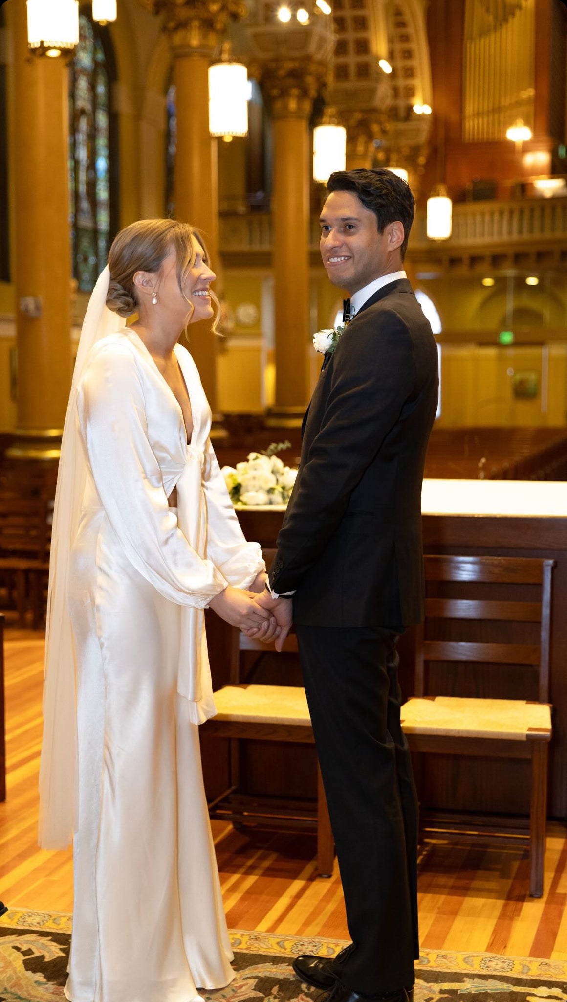 Couple married in church - bride wearing tie front bridal dress with veil