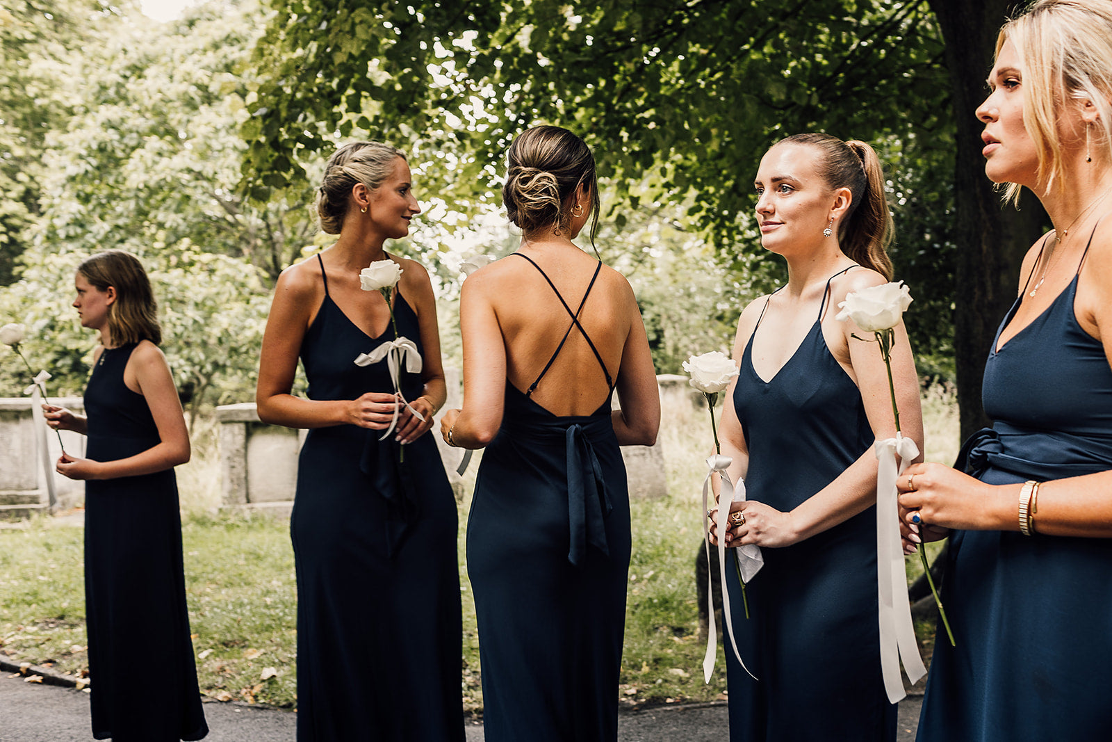 Eight bridesmaids in navy blue bridesmaids dresses.