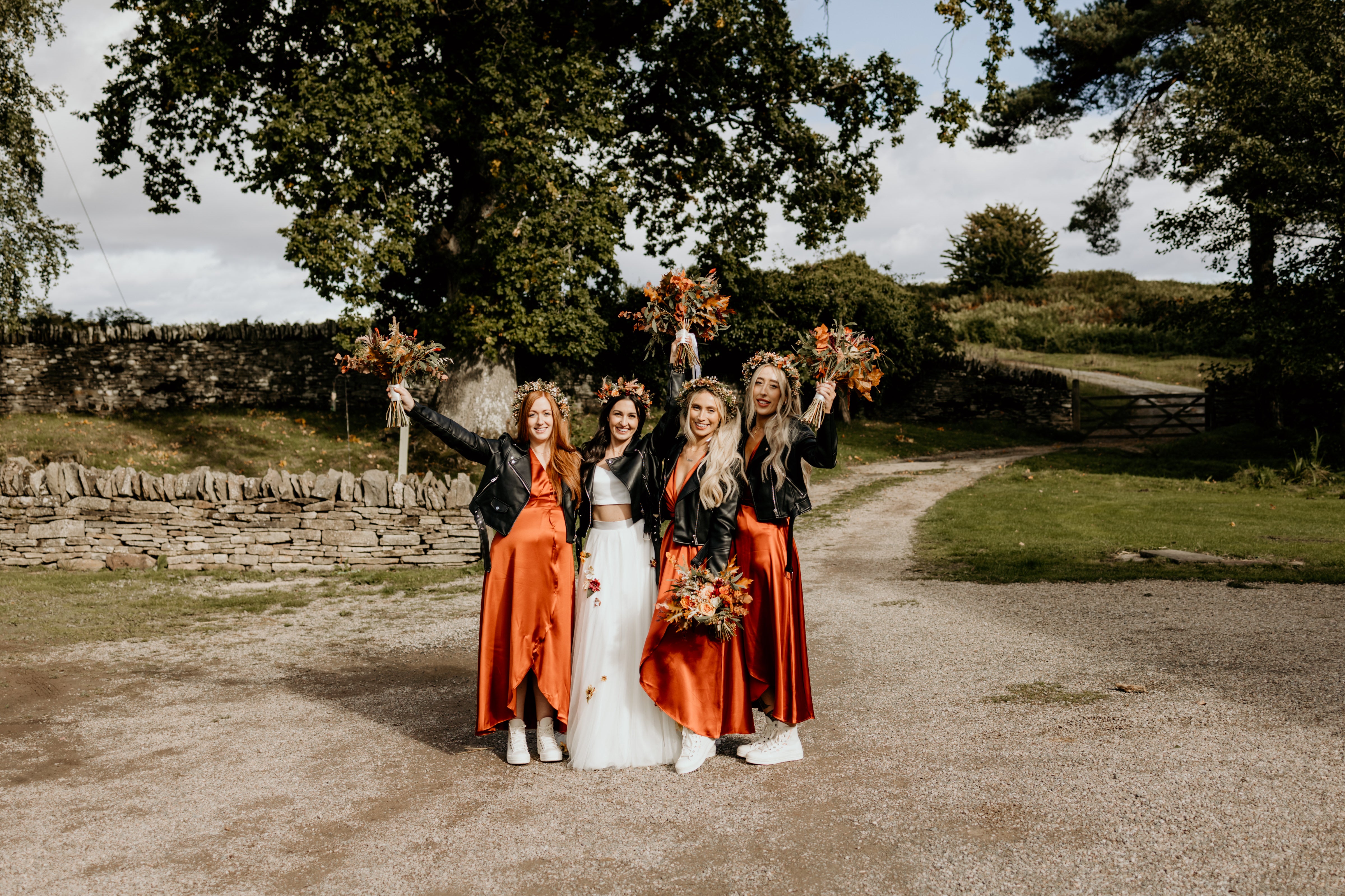 Burnt orange satin wrap bridesmaids dresses, styled with leather jackets and converse.