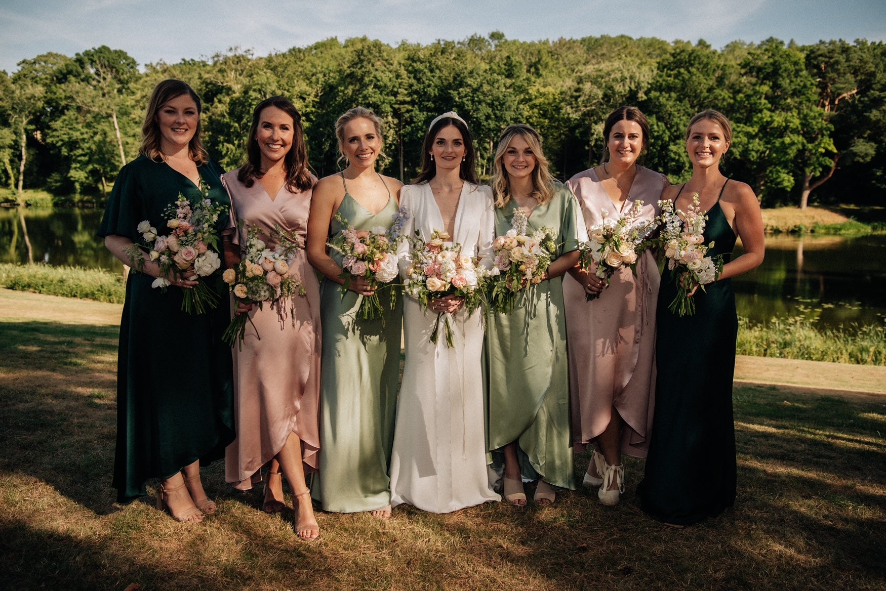 A bridal party of girls which includes a bride and 5 bridesmaids in pink and green bridesmaids dresses