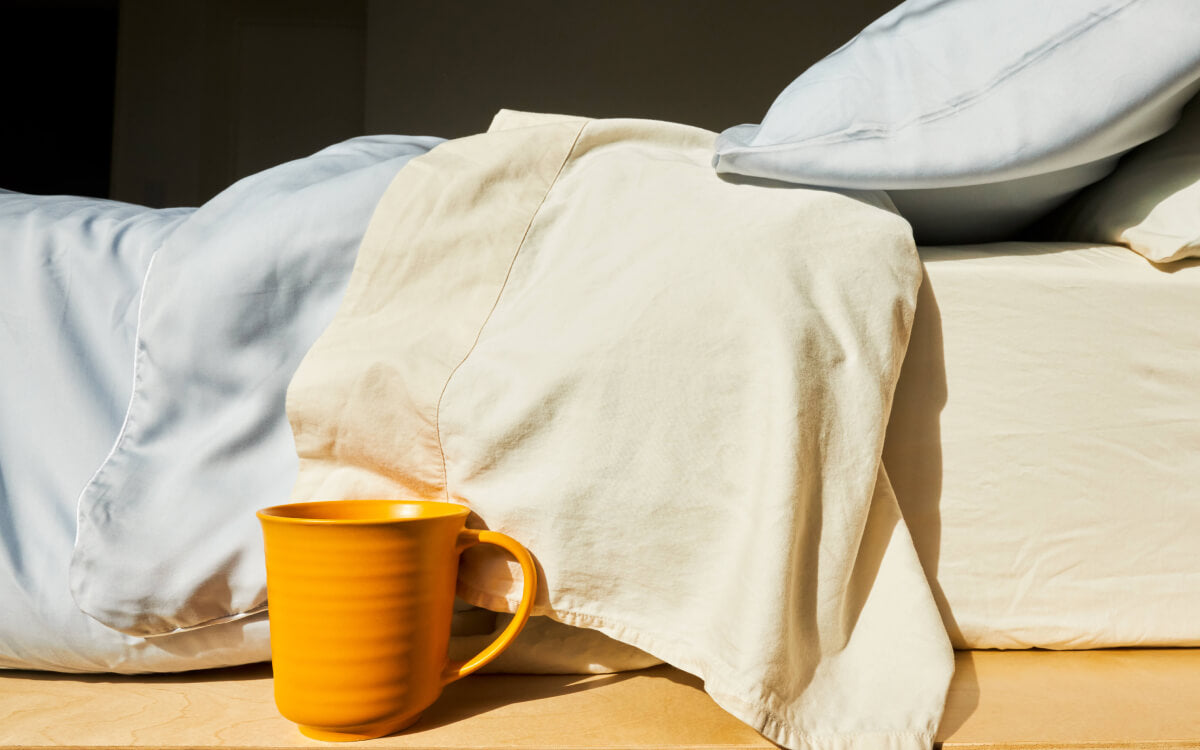 Slumber Cloud Best Bedding for Night Sweats - Yellow coffee mug sits bedside