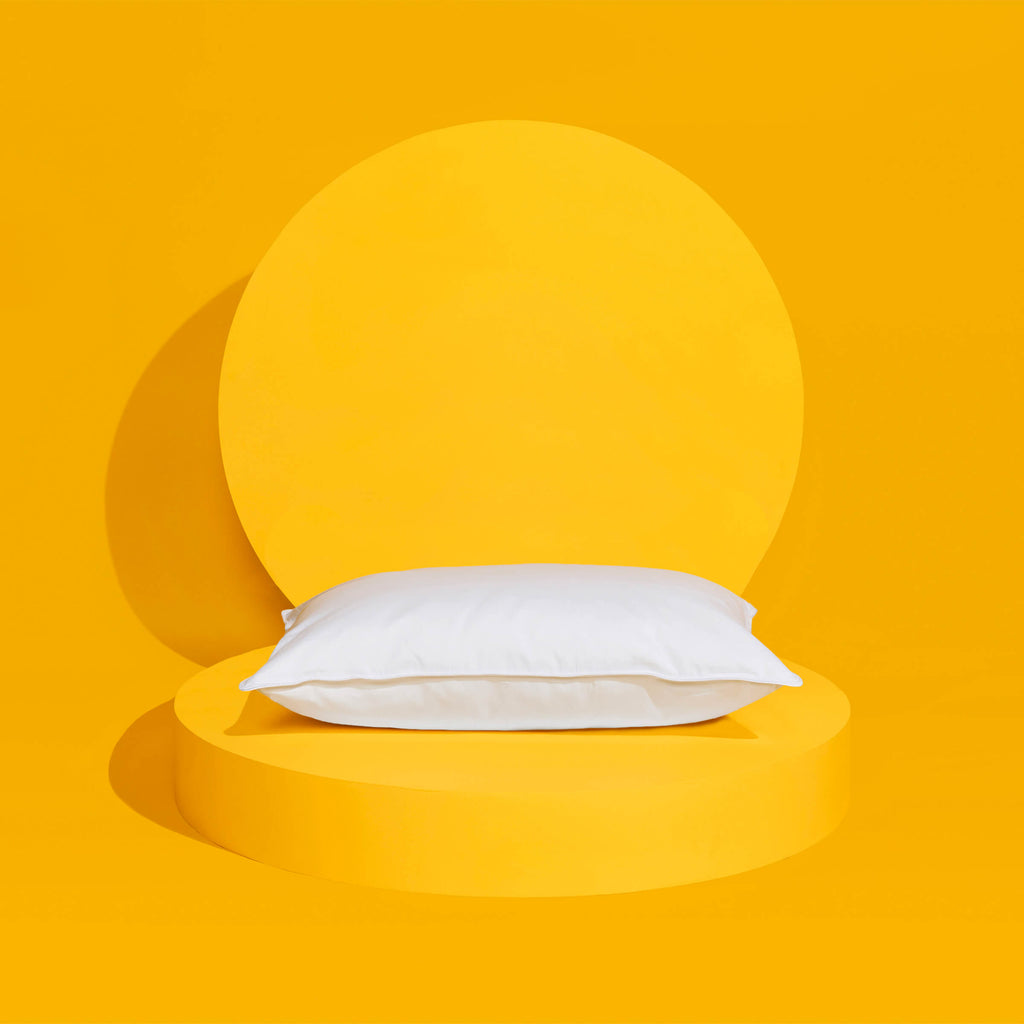 这款睡眠云芯羽绒枕头采用了温度调节技术，支撑在黄色背景上