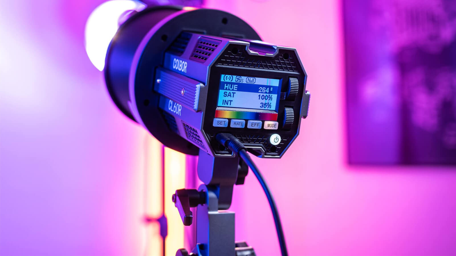 COLBOR CL60R RGB LED video light illuminates the scene with purple lighting.