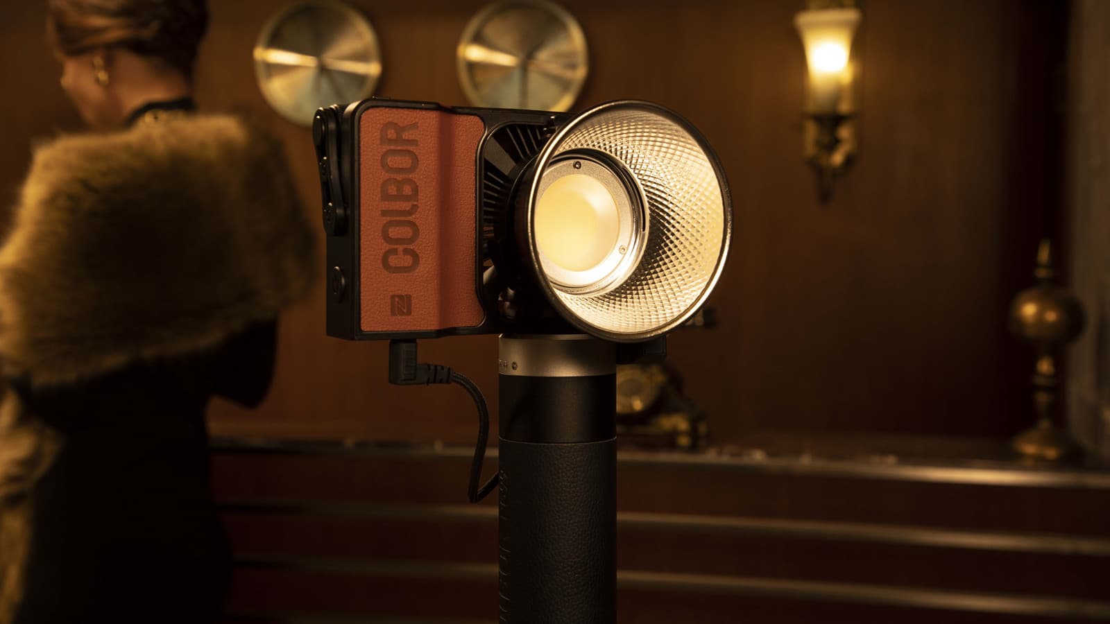 COLBOR W100 camcorder LED video light can be powered by a battery grip.