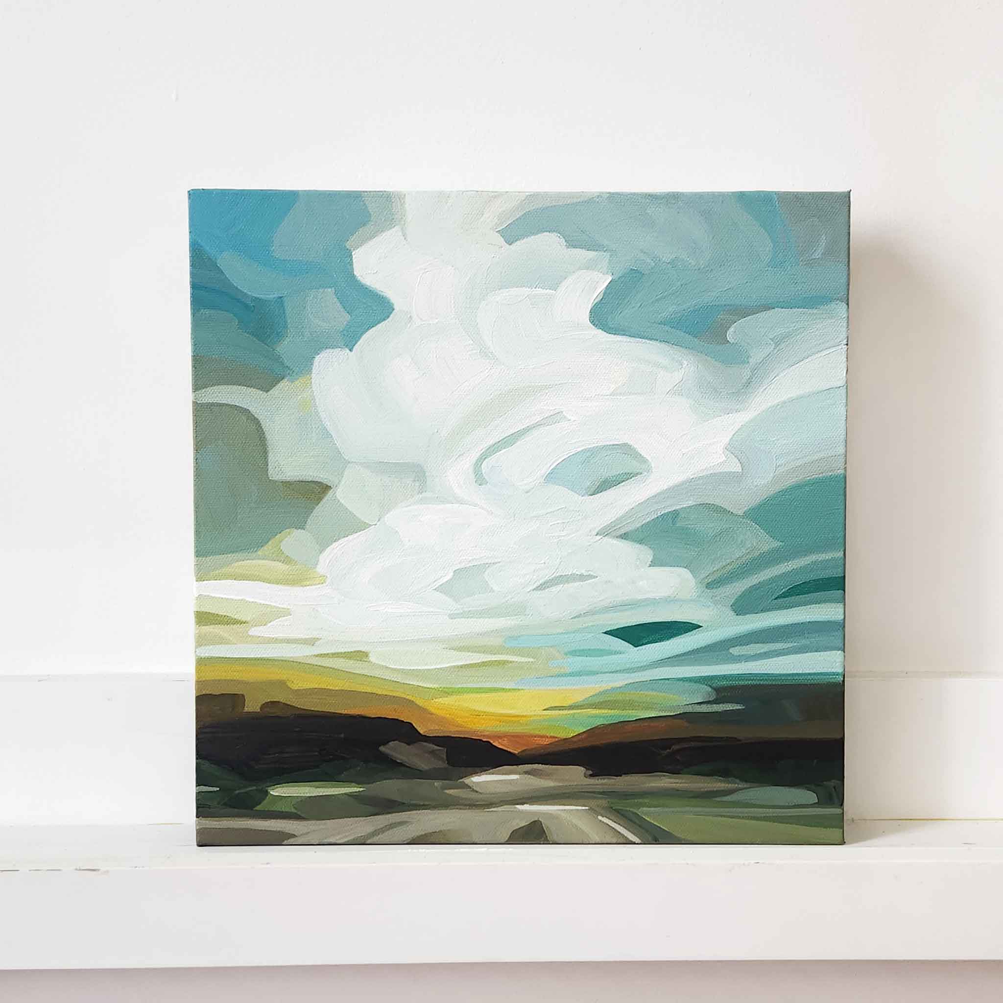 teal green sky painting with yellow sunburst on the horizon