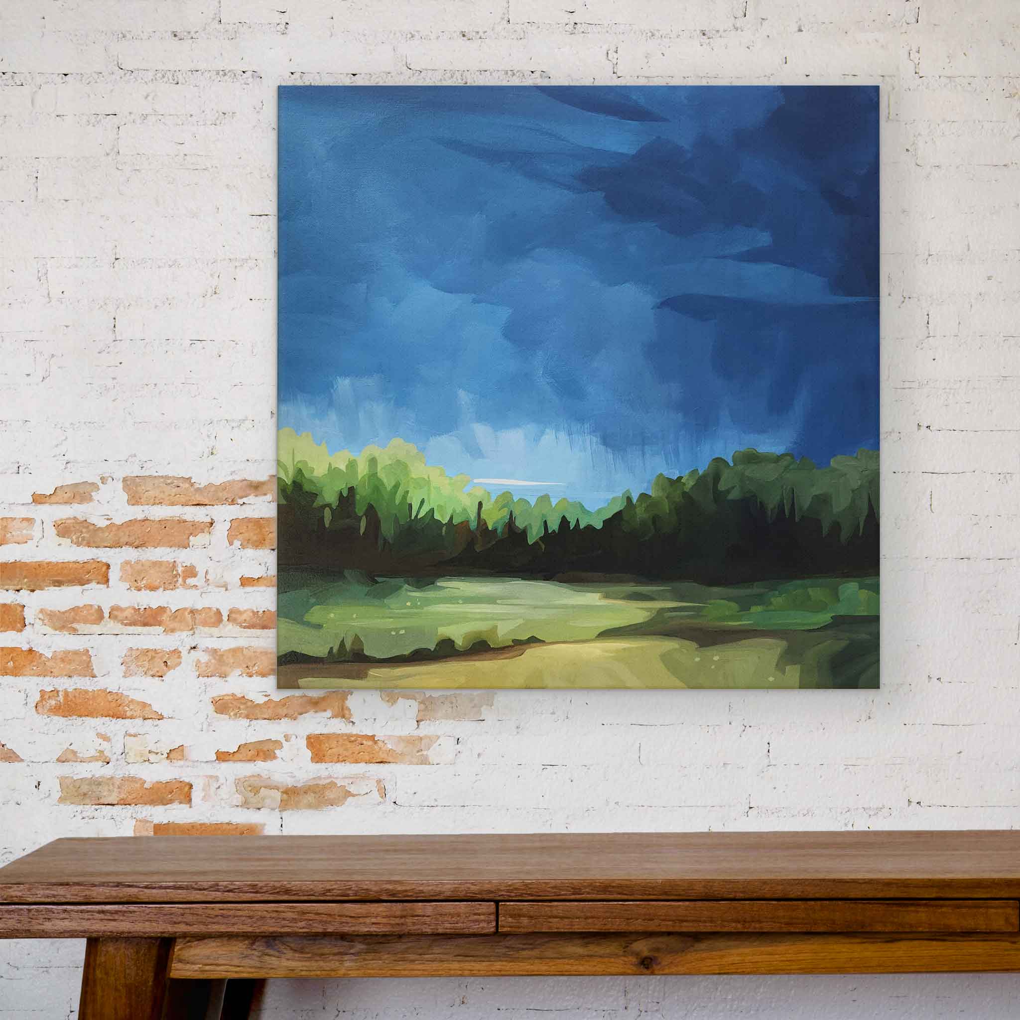 abstract landscape painting with wide open blue sky hanging over table