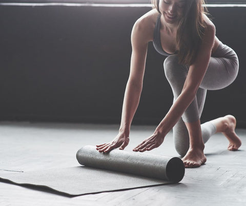 woman unrolling yoga mat