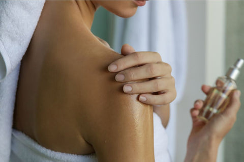 Woman putting on perfume