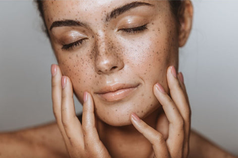 Femme touchant la peau de son visage