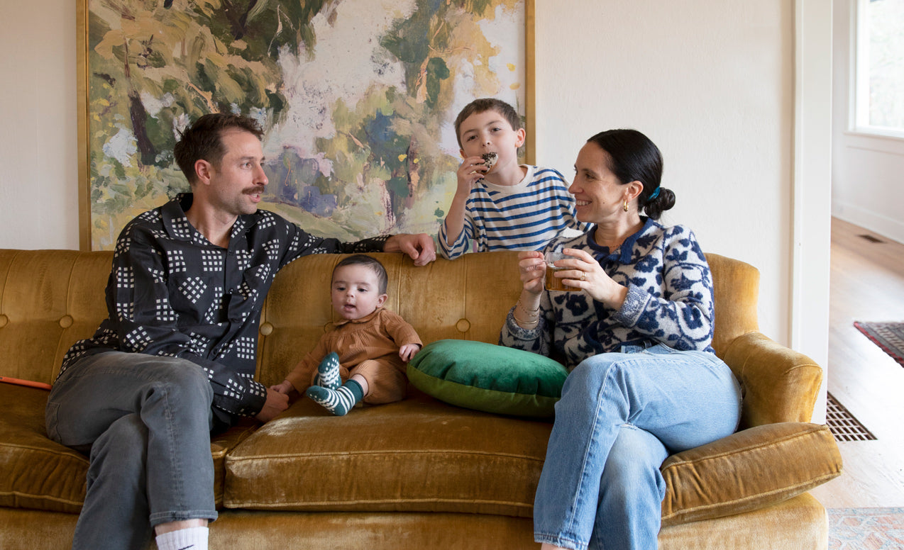 family of four sitting on a yellow couch