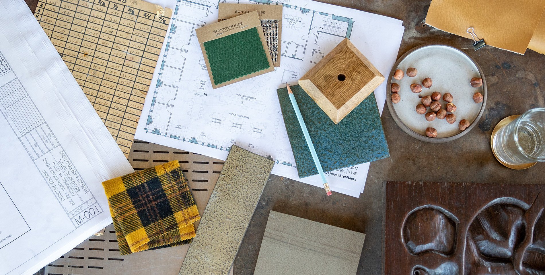 Design floor plan, materials, fabrics samples, textiles, and more on top of a concrete table.