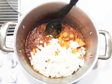 agregue cebolla y zanahorias al chorizo ​​cocido para sopa de frijoles en una olla de inducción de acero inoxidable 21 de 6 cuartos